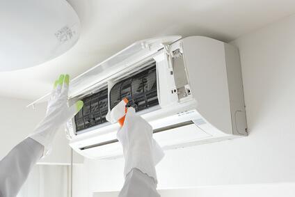 L'entretien du climatiseur fait par un agent équipé de gants